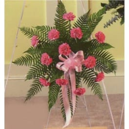 Standing spray of pink carnations with a pink ribbon on an easel