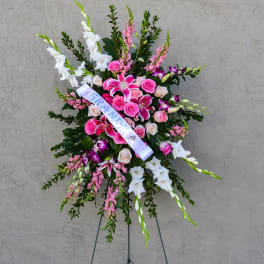 Standing floral spray with pink and white flowers and a white ribbon