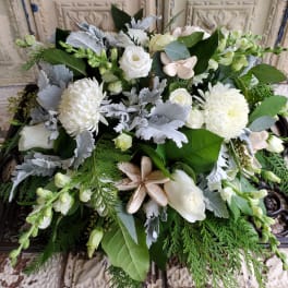 White floral arrangement with roses, mums, and greenery