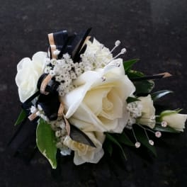 White rose corsage with black and gold ribbon accents