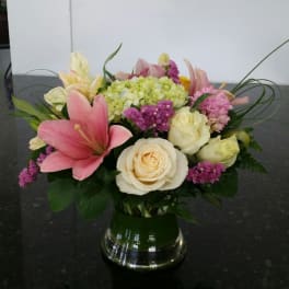 Pink lilies and cream roses in a glass vase