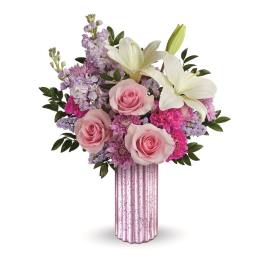 Pink roses and white lilies in a pink glass vase