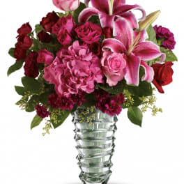 Pink and red floral arrangement in a clear glass vase