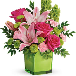 Pink lilies and roses in a green square vase
