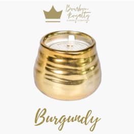 Gold candle in a rounded metallic holder with a white wick