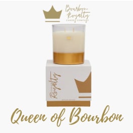 Gold and white candle in a glass jar on a branded box