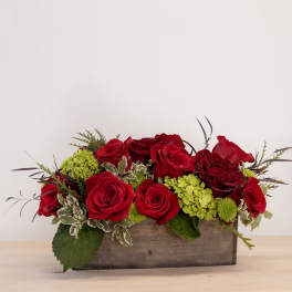 Red roses and green hydrangeas arranged in a wooden box
