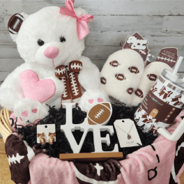 Basket of teddy bears and football-themed gifts with a LOVE sign