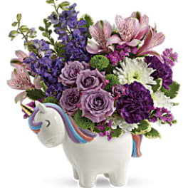 Purple and pink flowers arranged in a unicorn-shaped vase