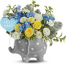 Blue and yellow flower arrangement in a gray elephant planter with a "Hello Baby!" sign
