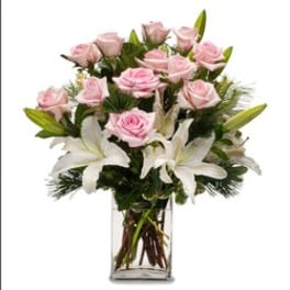 Pink roses and white lilies arranged in a clear glass vase.