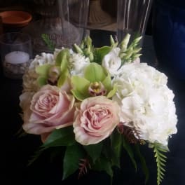 Pink roses and white hydrangeas with green orchids in a low arrangement