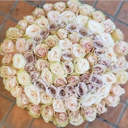 Large round bouquet of pale pink and cream roses on a tiled floor