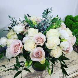 Bouquet of pale pink and white roses in a dark vase