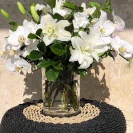 White orchids and lilies arranged in a clear glass vase