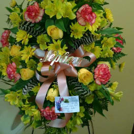 Standing floral spray with yellow and pink flowers on an easel