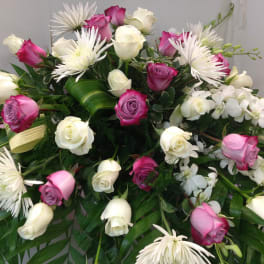 Pink and white roses with white spider mums in a large arrangement