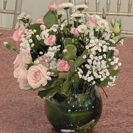 Pink and white flowers arranged in a dark glass vase