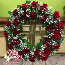Heart-shaped wreath of red roses and white baby's breath on an easel