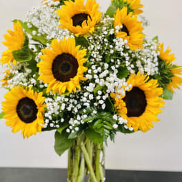 Bouquet of sunflowers and white baby's breath in a glass vase