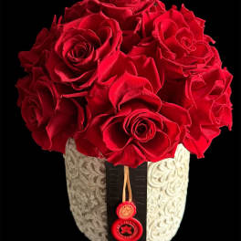 Red roses arranged in a decorative white vase