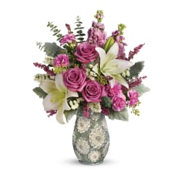 Pink roses and white lilies in a decorative glass vase