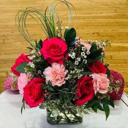 Bouquet of red roses and pink carnations in a glass vase