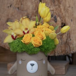 Yellow flowers arranged in a bear-shaped pot