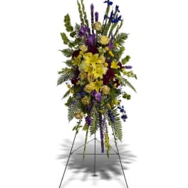 Standing floral spray with yellow and purple flowers on a metal easel