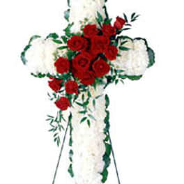 Standing cross of red roses and white flowers on an easel