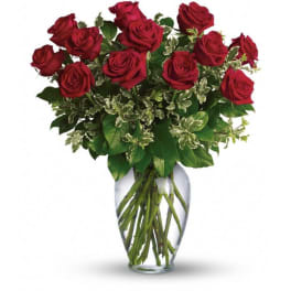 Red roses arranged in a clear glass vase
