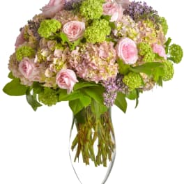 Pink roses and hydrangeas in a clear glass vase