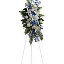 Tall blue and white floral standing spray on a metal easel