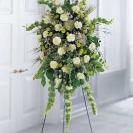 Tall white and green floral standing arrangement on an easel