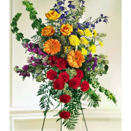 Tall standing floral spray with red, orange, yellow, and purple flowers