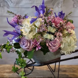 Mixed bouquet in a metal container with purple, pink, and white flowers