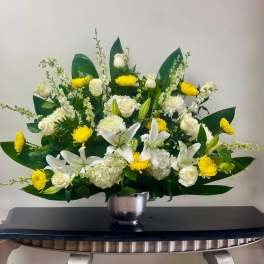 White lilies and roses with yellow mums in a silver vase