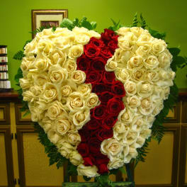 Heart-shaped rose arrangement with red center and cream roses