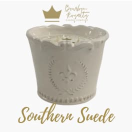 Cream-colored decorative candle in an embossed ceramic container