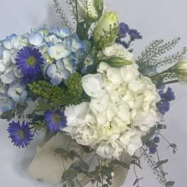 Bouquet of blue hydrangeas, white blooms, and purple daisies