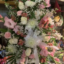 Large pink and white floral spray with a white ribbon bow