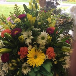 Mixed bouquet with lilies, daisies, and carnations in a basket