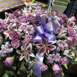 Lavender and pink floral spray with a purple ribbon and "grieving Mother" sign