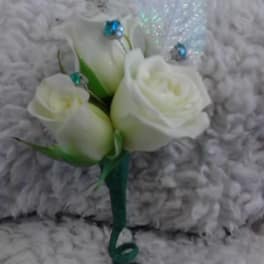 Small white rose corsage with green ribbon and blue accents