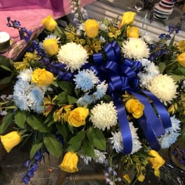 Yellow roses and white chrysanthemums arranged with a blue ribbon bow