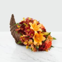 Autumn flower arrangement in a woven cornucopia basket