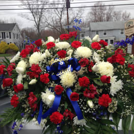 Large red, white, and blue funeral spray with ribbon tribute