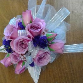 Small bouquet of pink roses with silver ribbon and purple accents