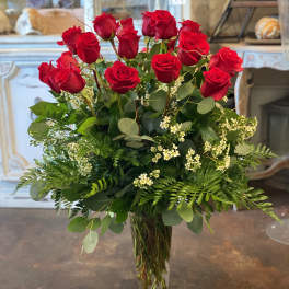 Tall bouquet of red roses in a clear glass vase