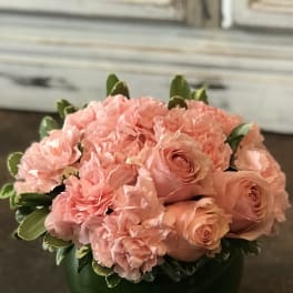Pink roses and carnations arranged in a green vase